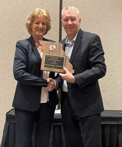 CHERYL BURNETT receiving the Gary Filbert Award