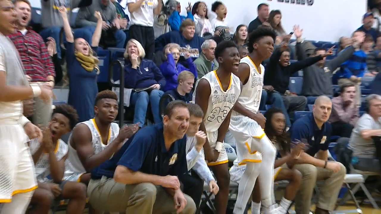 basketball players cheering on their teammates from the bench alongside their MBCA coach